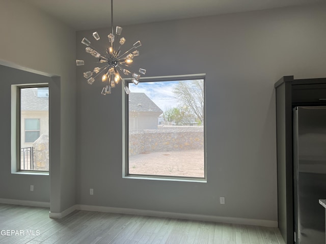 497 Plateau Dr, Socorro, TX 79927 - unfurnished dining area with a chandelier, healthy amount of natural light, and wood finished floors