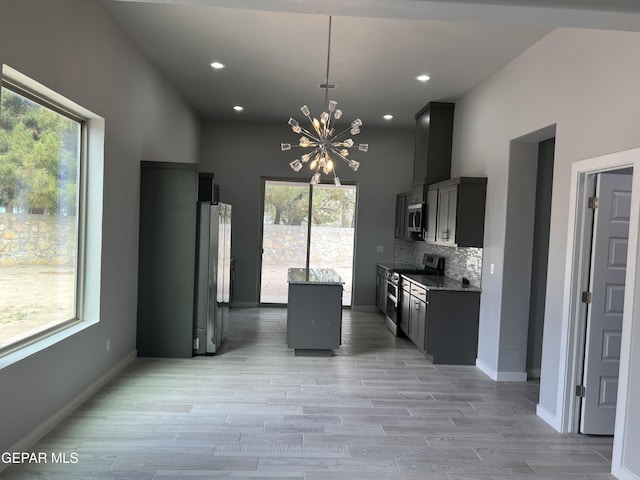 497 Plateau Dr, Socorro, TX 79927 - kitchen with appliances with stainless steel finishes, a chandelier, a kitchen island, light wood finished floors, and recessed lighting