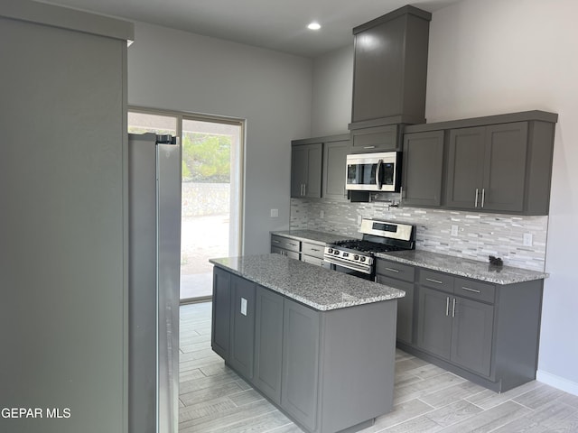 497 Plateau Dr, Socorro, TX 79927 - kitchen featuring stainless steel appliances, backsplash, a kitchen island, gray cabinets, and light stone countertops