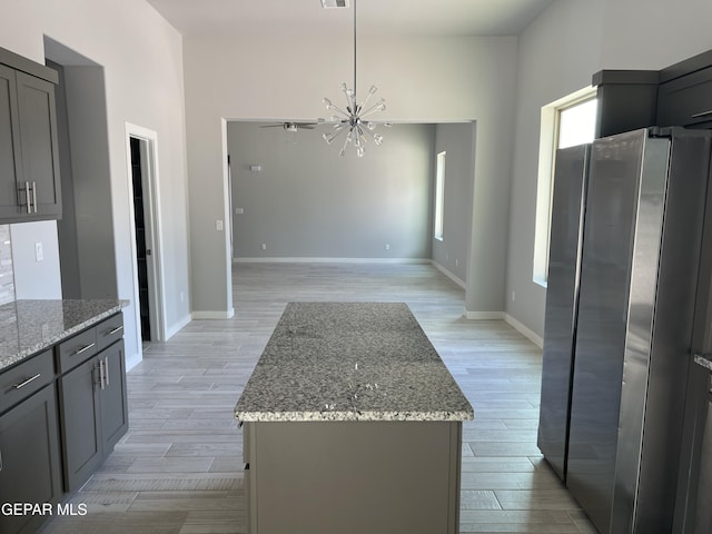 497 Plateau Dr, Socorro, TX 79927 - kitchen with freestanding refrigerator, light wood-style flooring, a chandelier, and light stone counters