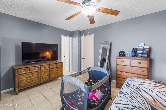 2297 Lisa Sherr St, El Paso, TX 79938 - bedroom featuring light tile patterned flooring, baseboards, ceiling fan, and a textured ceiling