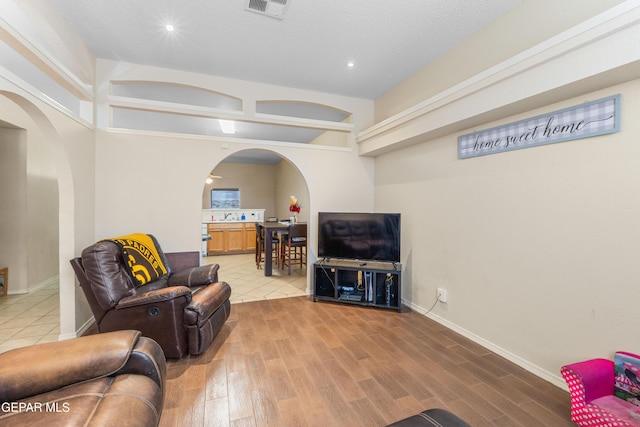 2297 Lisa Sherr St, El Paso, TX 79938 - living room with arched walkways, wood finished floors, recessed lighting, and baseboards