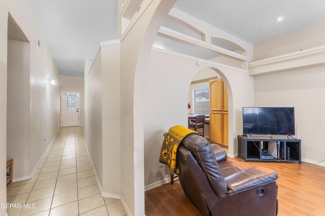 2297 Lisa Sherr St, El Paso, TX 79938 - corridor featuring arched walkways, baseboards, wood finished floors, and a textured ceiling