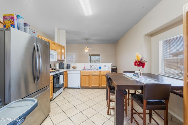 2297 Lisa Sherr St, El Paso, TX 79938 - kitchen with white appliances, a sink, light tile patterned floors, and light countertops