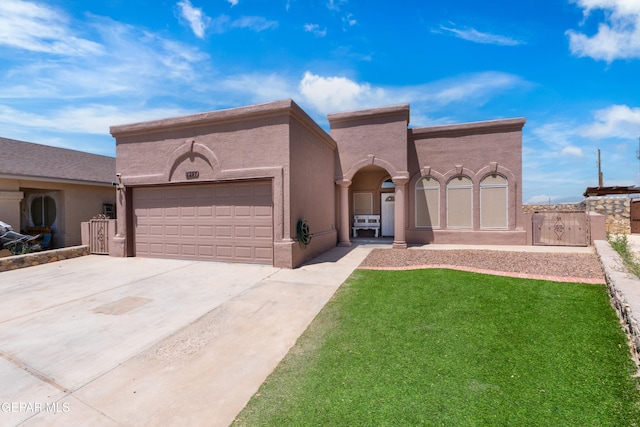 2297 Lisa Sherr St, El Paso, TX 79938 - view of front of property featuring a garage, driveway, a front lawn, stucco siding, and a gate