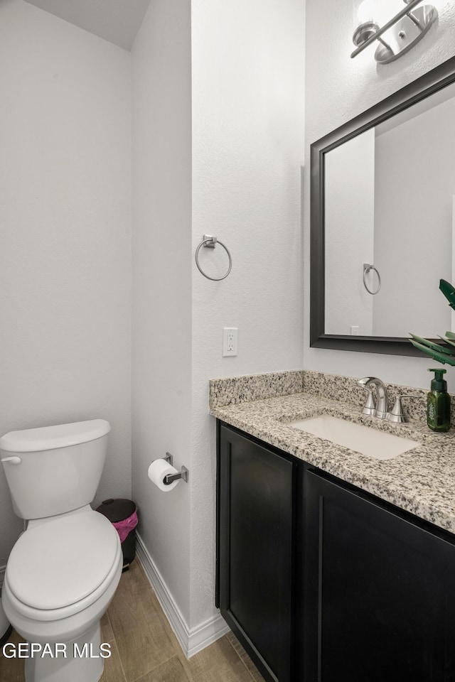 1669 Sam Dominguez, El Paso, TX 79928 - half bathroom featuring vanity, toilet, wood finished floors, and baseboards