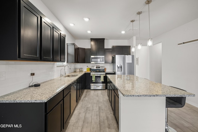 1669 Sam Dominguez, El Paso, TX 79928 - kitchen featuring stainless steel appliances, a sink, light wood finished floors, a center island, and tasteful backsplash