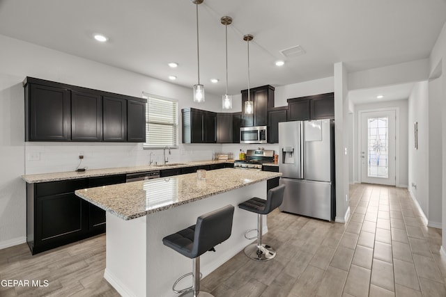 1669 Sam Dominguez, El Paso, TX 79928 - kitchen featuring appliances with stainless steel finishes, healthy amount of natural light, a breakfast bar area, light wood-style flooring, and recessed lighting