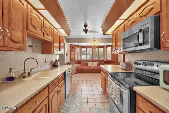 1126 Loma Verde Dr, El Paso, TX 79936 - kitchen featuring appliances with stainless steel finishes, a sink, light countertops, a chandelier, and a textured ceiling