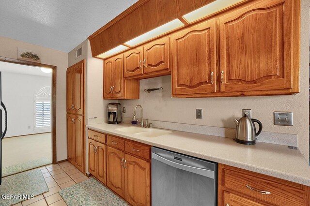 1126 Loma Verde Dr, El Paso, TX 79936 - kitchen featuring stainless steel dishwasher, a sink, light countertops, brown cabinets, and light tile patterned floors