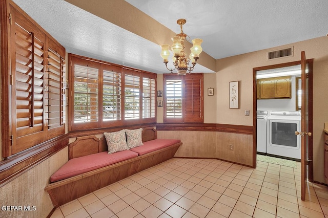 1126 Loma Verde Dr, El Paso, TX 79936 - living area featuring washing machine and clothes dryer, a textured ceiling, a chandelier, light tile patterned floors, and a wainscoted wall