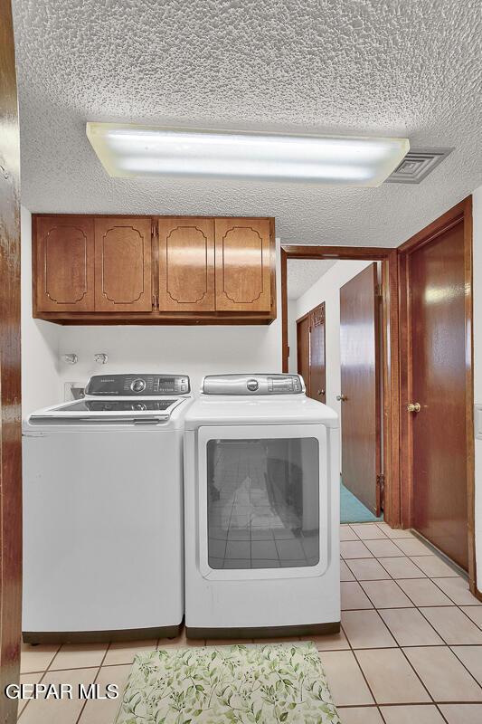 1126 Loma Verde Dr, El Paso, TX 79936 - washroom with a textured ceiling, separate washer and dryer, cabinet space, and light tile patterned flooring