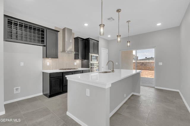 13865 Summer Wave Ave, Horizon City, TX 79928 - kitchen featuring wall chimney range hood, oven, a sink, stainless steel gas stovetop, and dark cabinetry