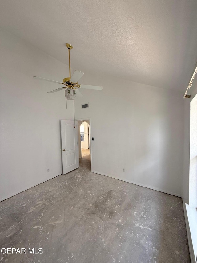 6840 Ridge Top Dr, El Paso, TX 79904 - empty room featuring a ceiling fan, lofted ceiling, arched walkways, and unfinished concrete floors