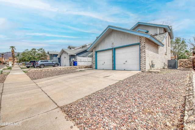4521 Loma De Plata Dr, El Paso, TX 79934 - view of home's exterior with central AC unit, an attached garage, concrete driveway, and brick siding