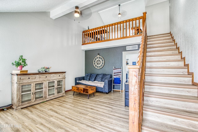 4521 Loma De Plata Dr, El Paso, TX 79934 - stairway featuring beam ceiling, wood finished floors, high vaulted ceiling, ceiling fan, and a textured wall