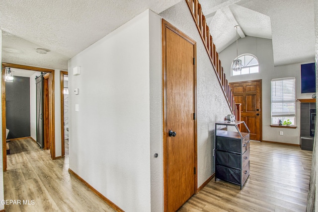 4521 Loma De Plata Dr, El Paso, TX 79934 - hall with a textured ceiling, light wood-style floors, baseboards, lofted ceiling, and stairs