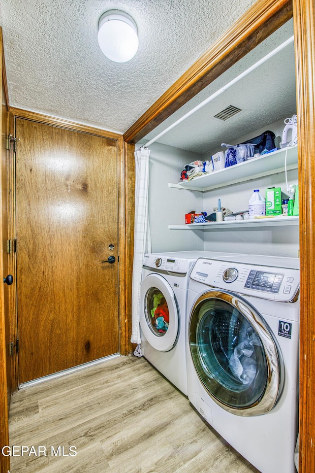 4521 Loma De Plata Dr, El Paso, TX 79934 - laundry area with a textured ceiling, washing machine and dryer, and wood finished floors