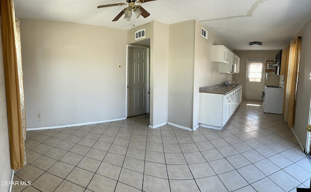 7800 Monterrey Dr, El Paso, TX 79915 - kitchen featuring washer / clothes dryer, ceiling fan, a sink, light tile patterned flooring, and white cabinets