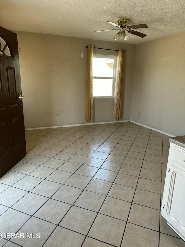 7800 Monterrey Dr, El Paso, TX 79915 - empty room with a textured ceiling, a ceiling fan, light tile patterned floors, and baseboards