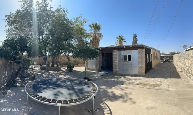 7800 Monterrey Dr, El Paso, TX 79915 - rear view of house featuring a fenced backyard, an outbuilding, brick siding, and a patio area