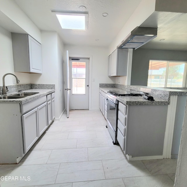 2916 Beachcomber, El Paso, TX 79936 - kitchen featuring stainless steel range oven, a sink, a peninsula, baseboards, and gray cabinetry