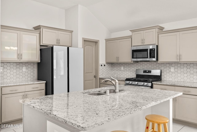 13804 Sky Ranger Ave, Horizon City, TX 79928 - kitchen featuring appliances with stainless steel finishes, a sink, backsplash, light stone countertops, and vaulted ceiling