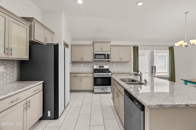 13804 Sky Ranger Ave, Horizon City, TX 79928 - kitchen featuring appliances with stainless steel finishes, a sink, a chandelier, backsplash, and a center island with sink