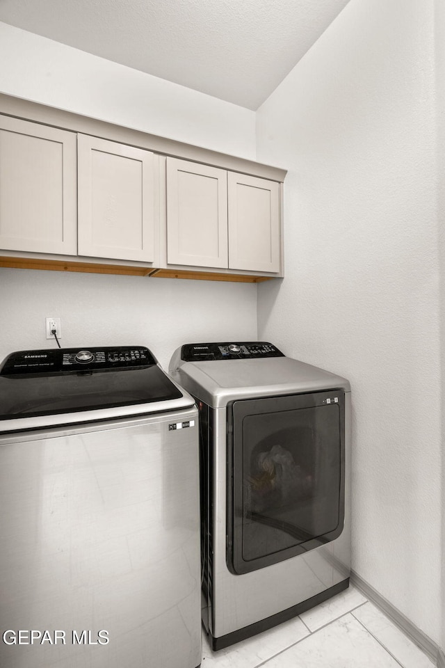 13804 Sky Ranger Ave, Horizon City, TX 79928 - laundry room with cabinet space, independent washer and dryer, baseboards, and light marble finish floors