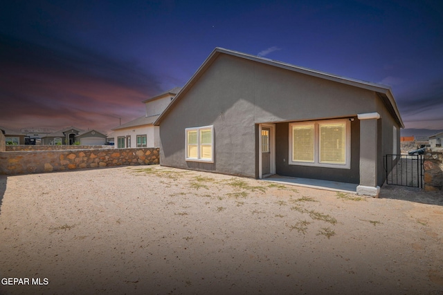 13804 Sky Ranger Ave, Horizon City, TX 79928 - back of house at dusk featuring stucco siding and a patio
