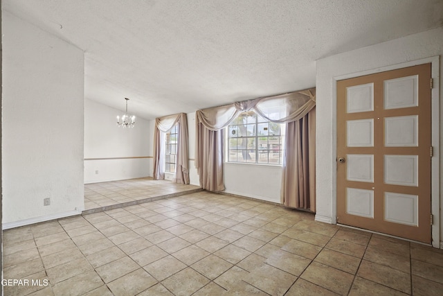 4112 Blackstone Ct, El Paso, TX 79922 - tiled empty room featuring a chandelier, a textured ceiling, vaulted ceiling, and baseboards