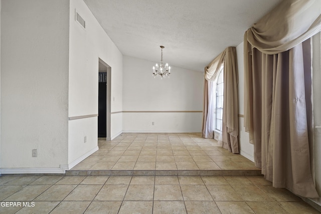 4112 Blackstone Ct, El Paso, TX 79922 - unfurnished dining area featuring a chandelier, light tile patterned floors, a textured ceiling, and baseboards