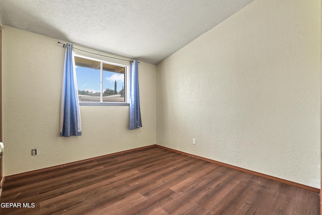 4112 Blackstone Ct, El Paso, TX 79922 - unfurnished room with dark wood finished floors, a textured wall, a textured ceiling, baseboards, and vaulted ceiling