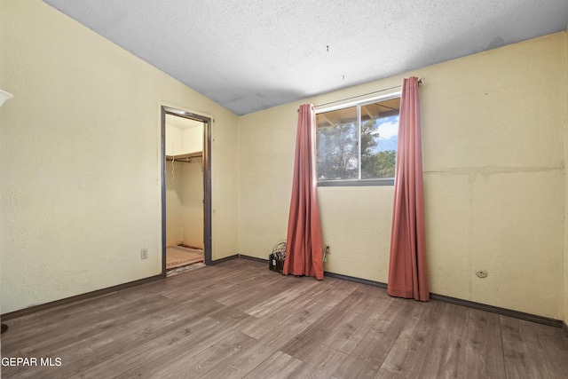 4112 Blackstone Ct, El Paso, TX 79922 - unfurnished bedroom featuring wood finished floors, vaulted ceiling, a textured ceiling, baseboards, and a closet