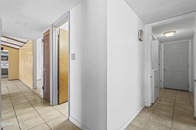 4112 Blackstone Ct, El Paso, TX 79922 - hallway with a textured ceiling, light tile patterned floors, baseboards, and washer / dryer