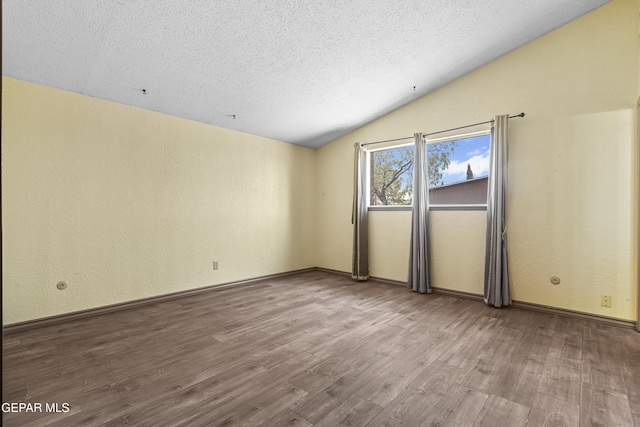 4112 Blackstone Ct, El Paso, TX 79922 - unfurnished room featuring vaulted ceiling, wood finished floors, a textured ceiling, a textured wall, and baseboards