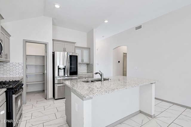 1129 Indigo Sky St, El Paso, TX 79928 - kitchen with appliances with stainless steel finishes, a sink, light marble finish floors, gray cabinets, and arched walkways