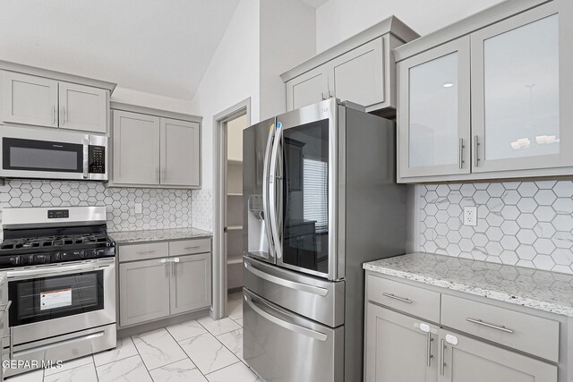 1129 Indigo Sky St, El Paso, TX 79928 - kitchen featuring appliances with stainless steel finishes, gray cabinetry, tasteful backsplash, and vaulted ceiling
