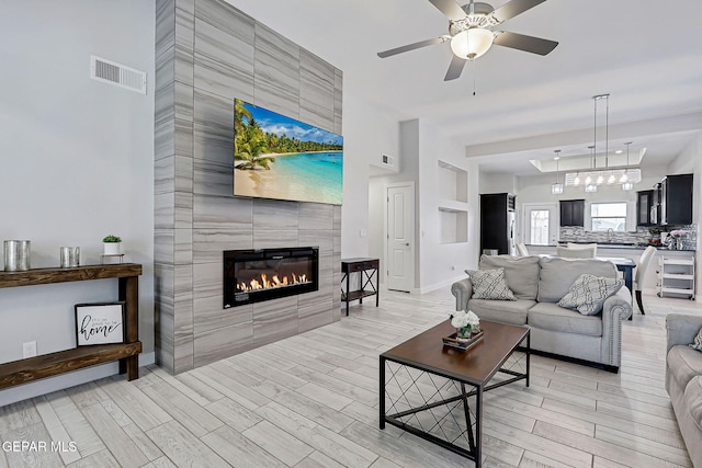 14733 Charles Foster Ave, El Paso, TX 79938 - living area with wood finish floors, a fireplace, ceiling fan, and baseboards