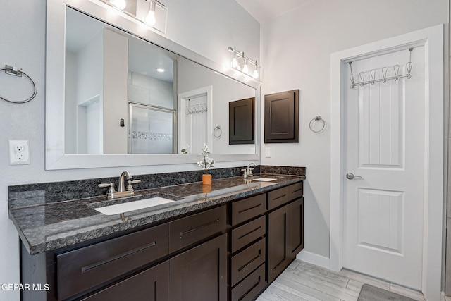 14733 Charles Foster Ave, El Paso, TX 79938 - full bath featuring double vanity, a stall shower, baseboards, and wood finished floors