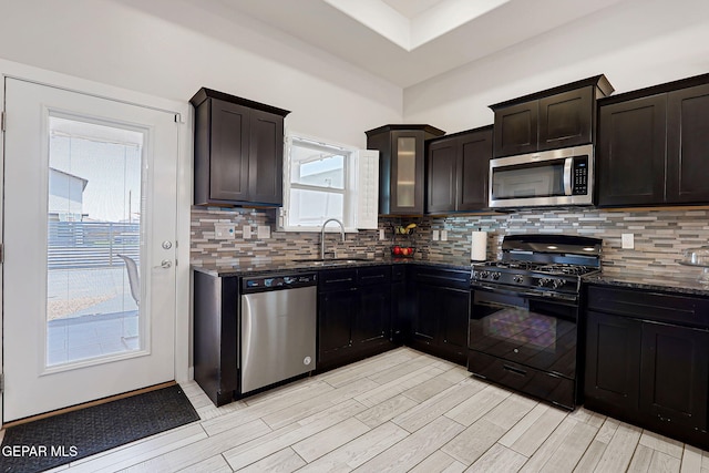 14733 Charles Foster Ave, El Paso, TX 79938 - kitchen featuring stainless steel appliances, a sink, dark stone countertops, and light wood-type flooring