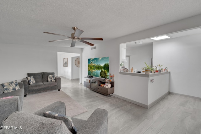 10109 Saigon Dr, El Paso, TX 79925 - living area with a textured ceiling, ceiling fan, light wood-type flooring, and baseboards