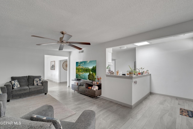 10109 Saigon Dr, El Paso, TX 79925 - living room featuring wood finish floors, a textured ceiling, a ceiling fan, and baseboards