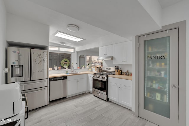 10109 Saigon Dr, El Paso, TX 79925 - kitchen featuring stainless steel appliances, a sink, under cabinet range hood, light countertops, and white cabinets
