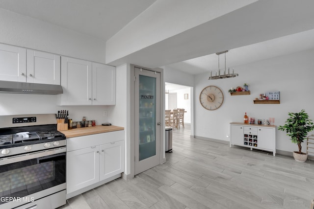 10109 Saigon Dr, El Paso, TX 79925 - kitchen with stainless steel gas stove, under cabinet range hood, and white cabinetry