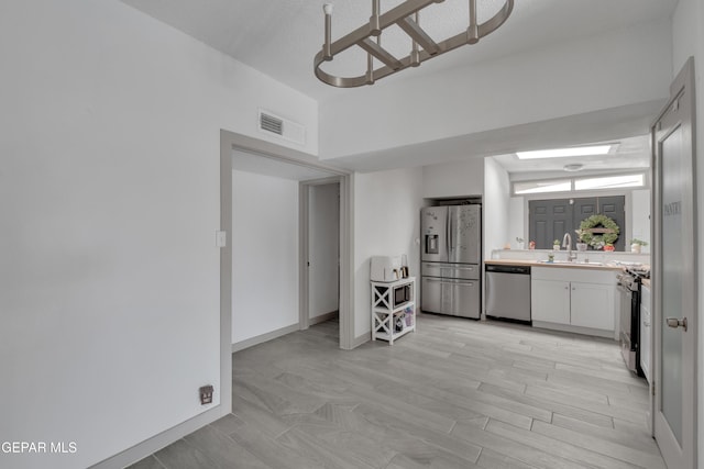 10109 Saigon Dr, El Paso, TX 79925 - kitchen featuring appliances with stainless steel finishes, a sink, light countertops, white cabinets, and baseboards