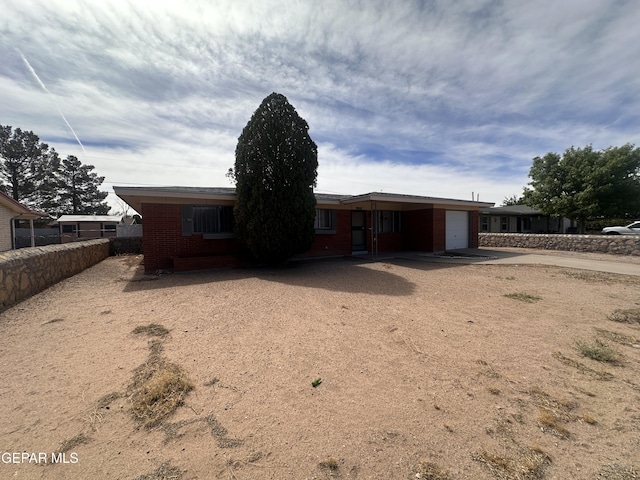 9868 Bomarc St, El Paso, TX 79924 - view of front of house with an attached garage, driveway, and brick siding