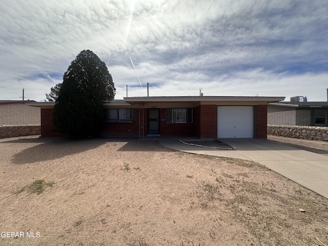 9868 Bomarc St, El Paso, TX 79924 - ranch-style home with a garage, driveway, and brick siding