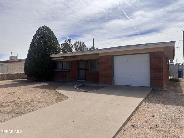 9868 Bomarc St, El Paso, TX 79924 - ranch-style home with concrete driveway, brick siding, and a garage