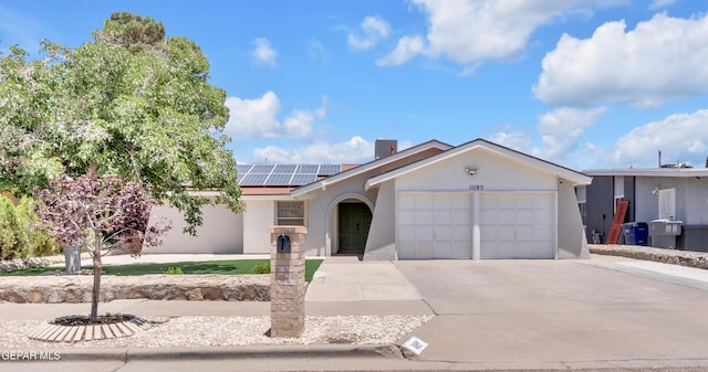 11185 Tenaha Ave, El Paso, TX 79936 - single story home with an attached garage, concrete driveway, solar panels, and stucco siding